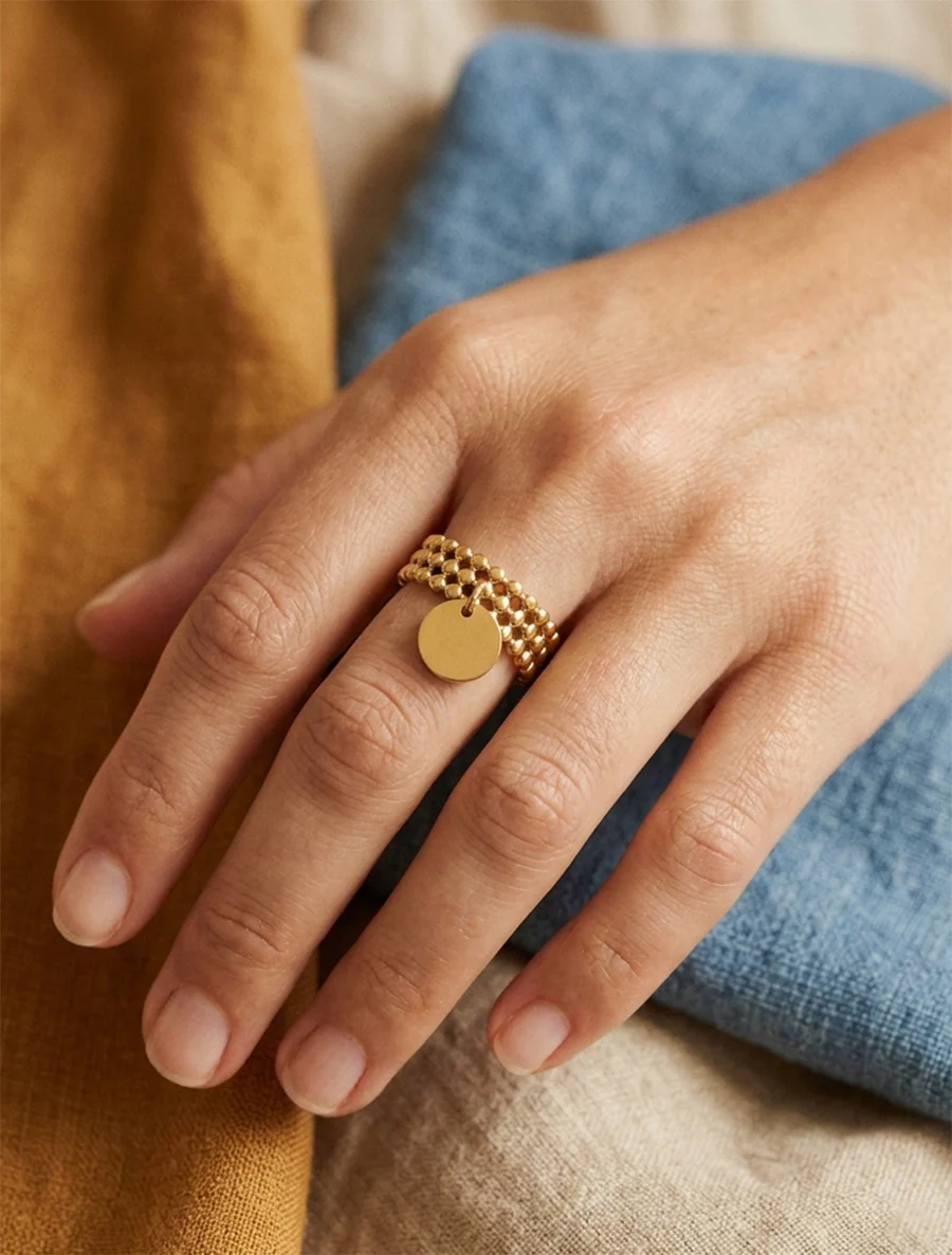 Kraalring met kleine kralen en ronde bedel. - Goud